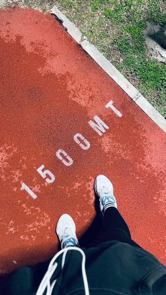 Top-down view of running track 1500m mark with white sneakers visible in Denizli, Türkiye.