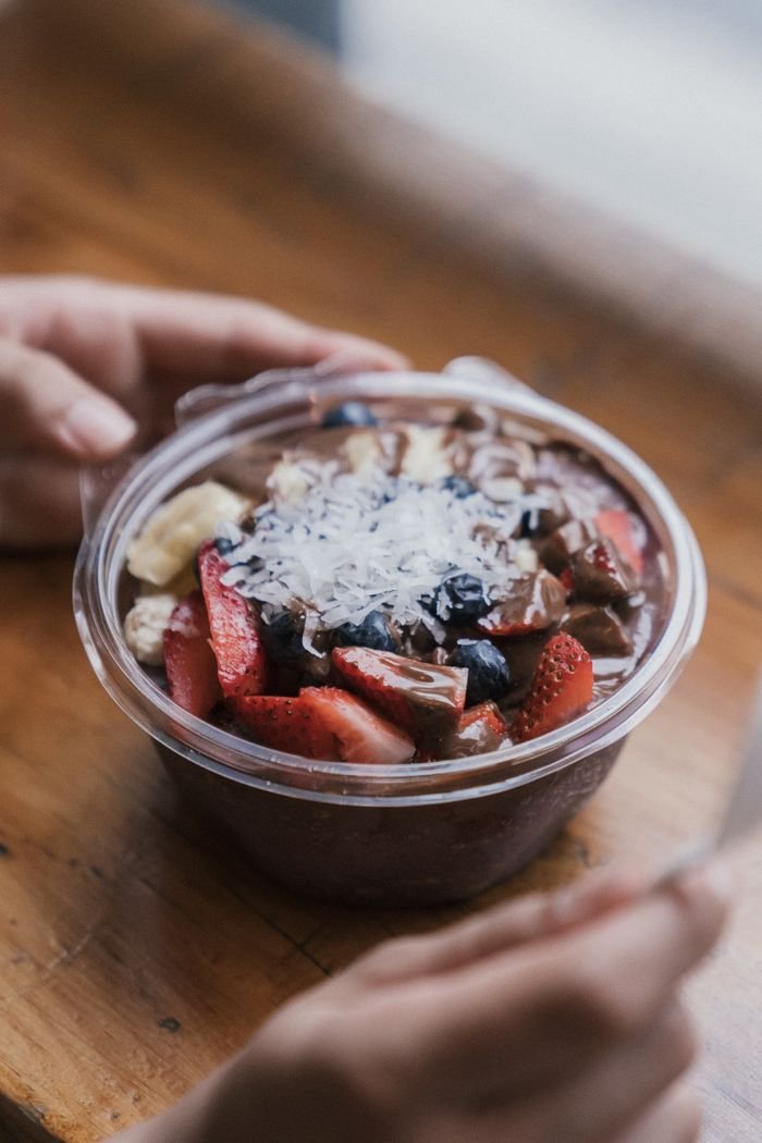 A vibrant açaí bowl topped with strawberries, bananas, blueberries, and coconut shavings, ideal for healthy eating inspiration.